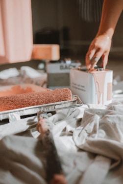 a person putting something in a box on a bed