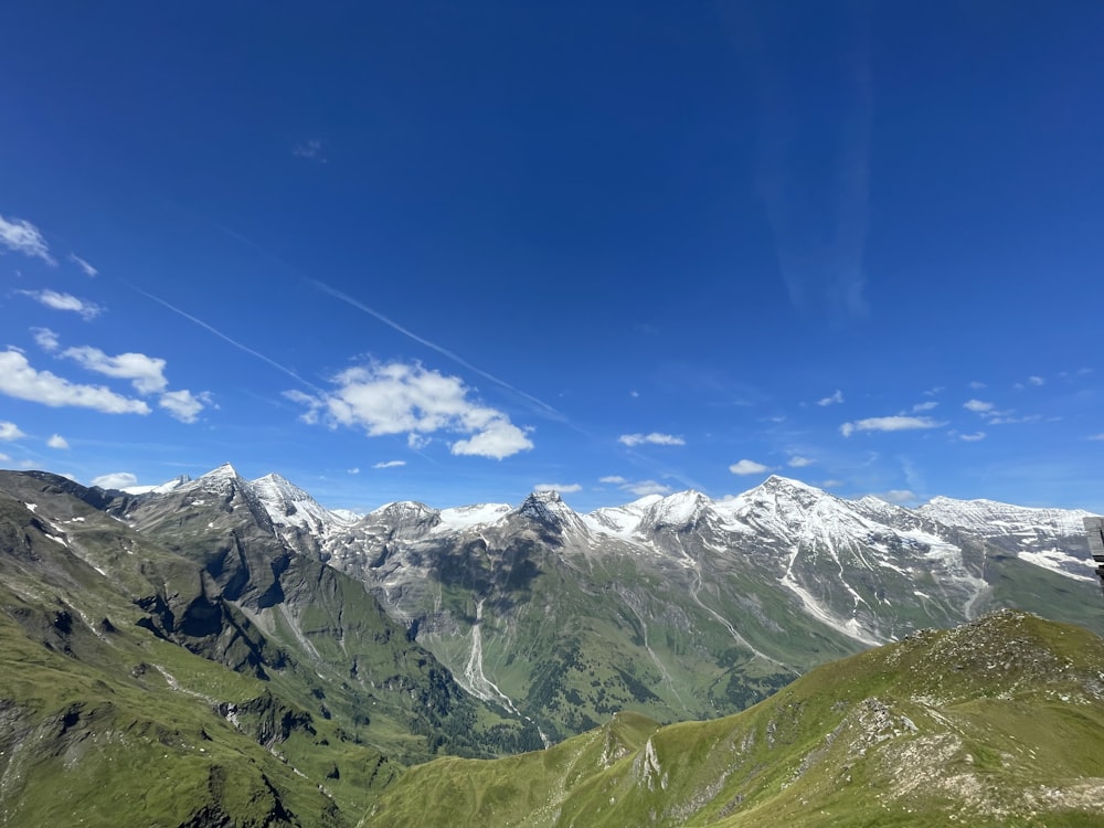 a view of a mountain range with snow capped mountains in the distance