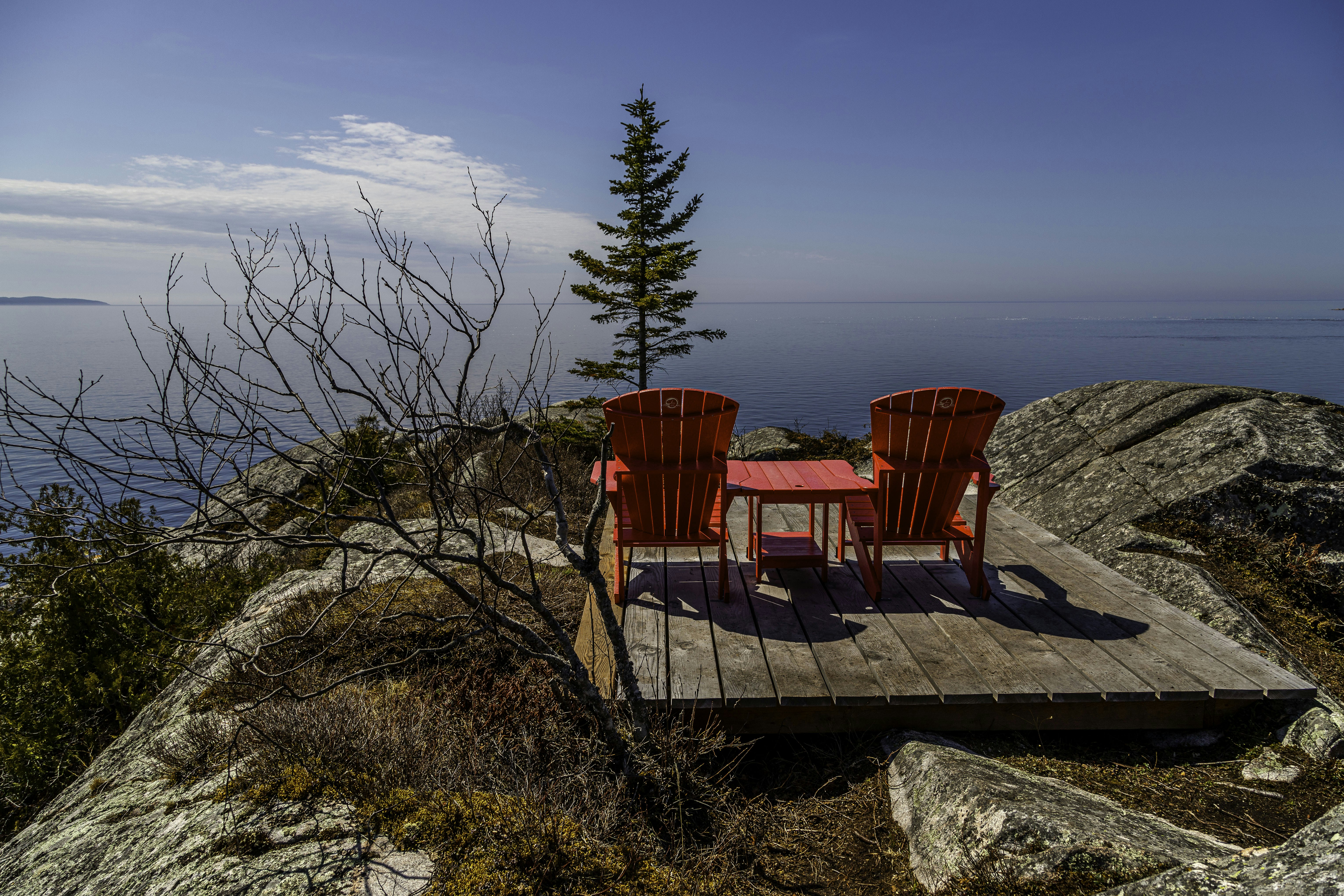 two red chairs sitting on top of a wooden platform