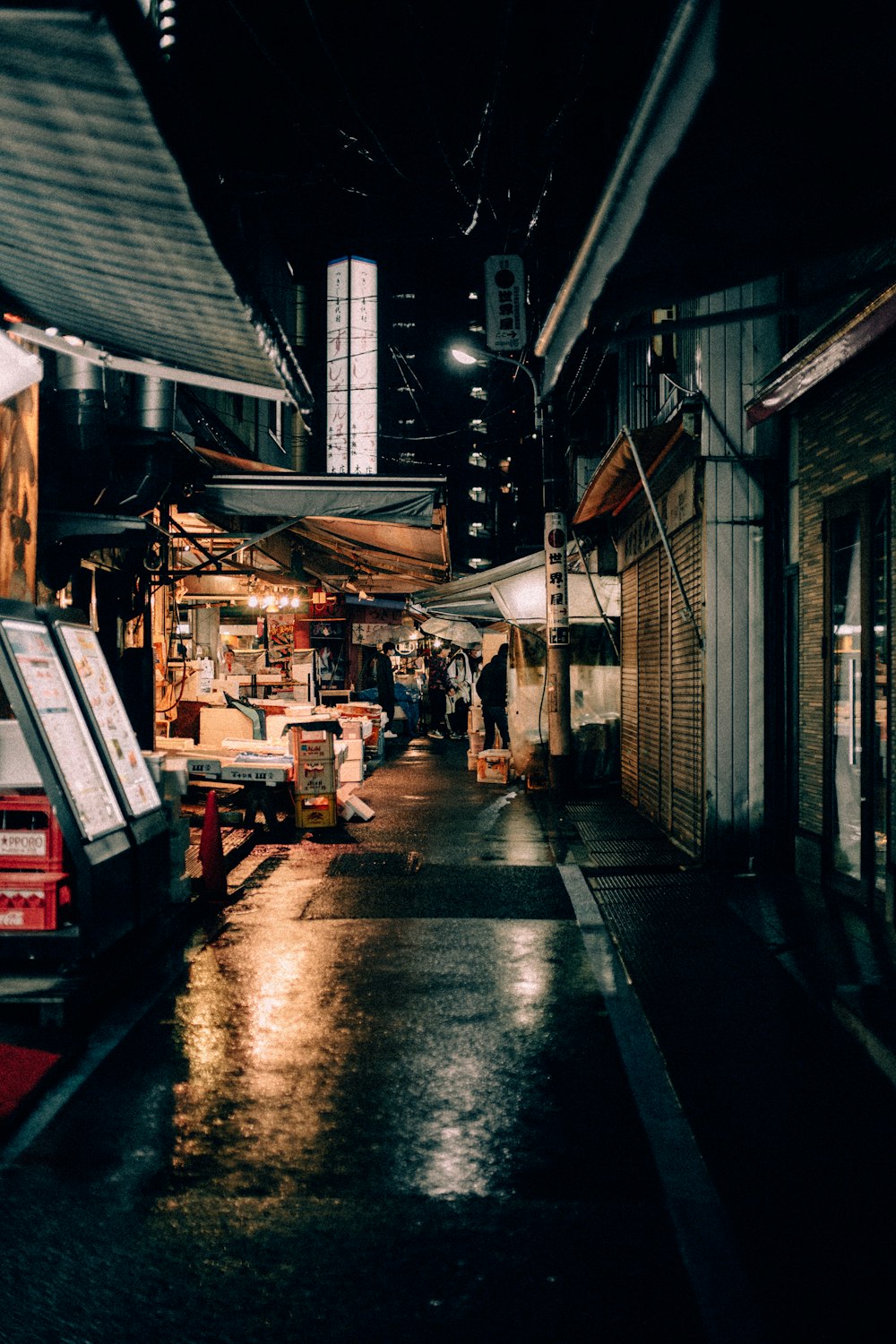 a dark alley with a few shops on the side of it