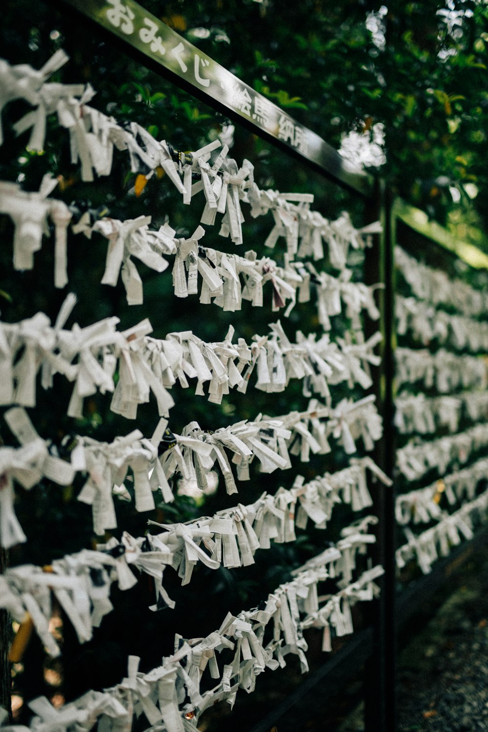 a bunch of white clothes hanging on a fence