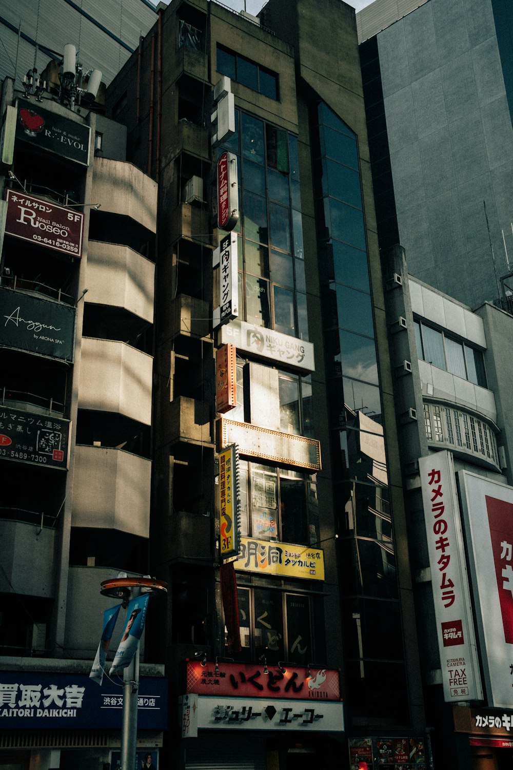 a tall building with lots of signs on the side of it