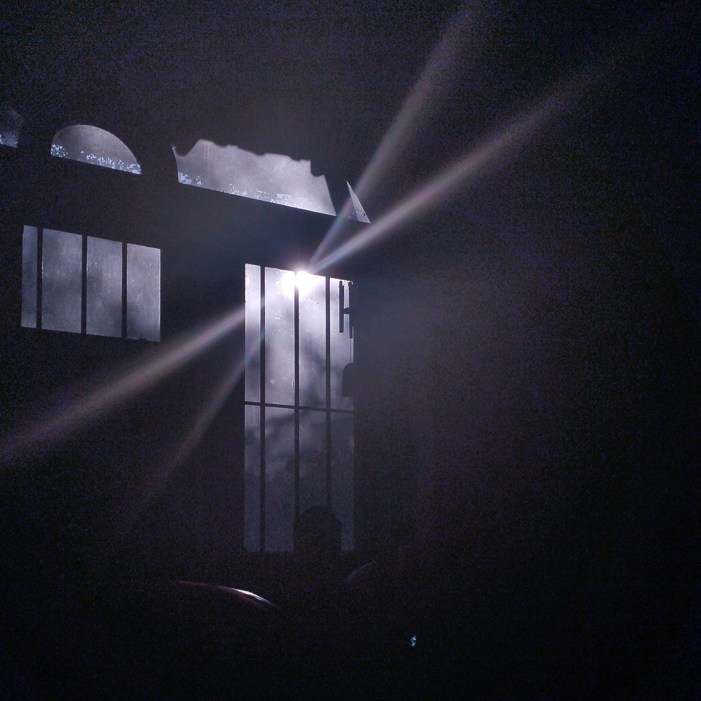 a dark room with a light coming through the window