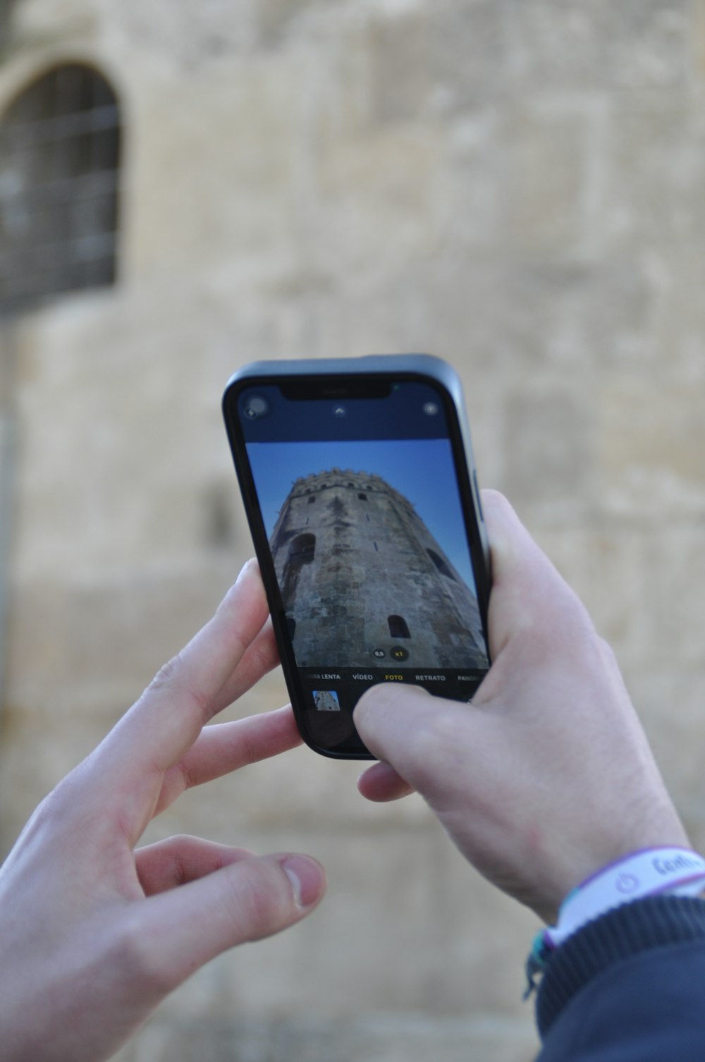 a person taking a picture of a tower with a cell phone