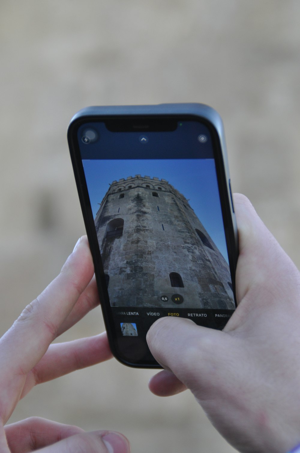 a person taking a picture of a tower with a cell phone