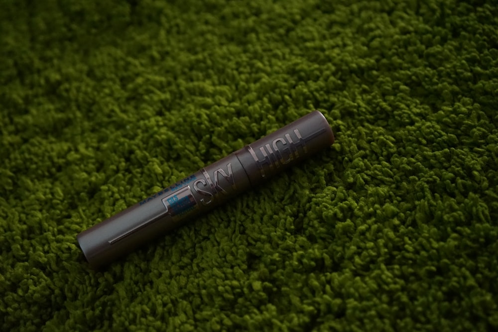 a black pen sitting on top of a green carpet