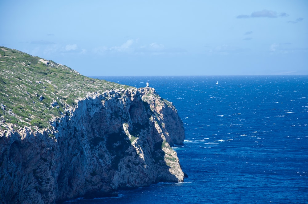 a person standing on the edge of a cliff overlooking the ocean