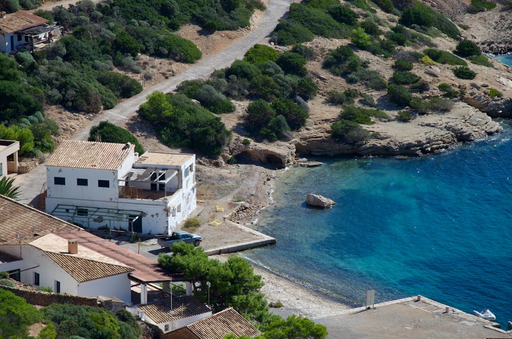 an aerial view of a house next to a body of water