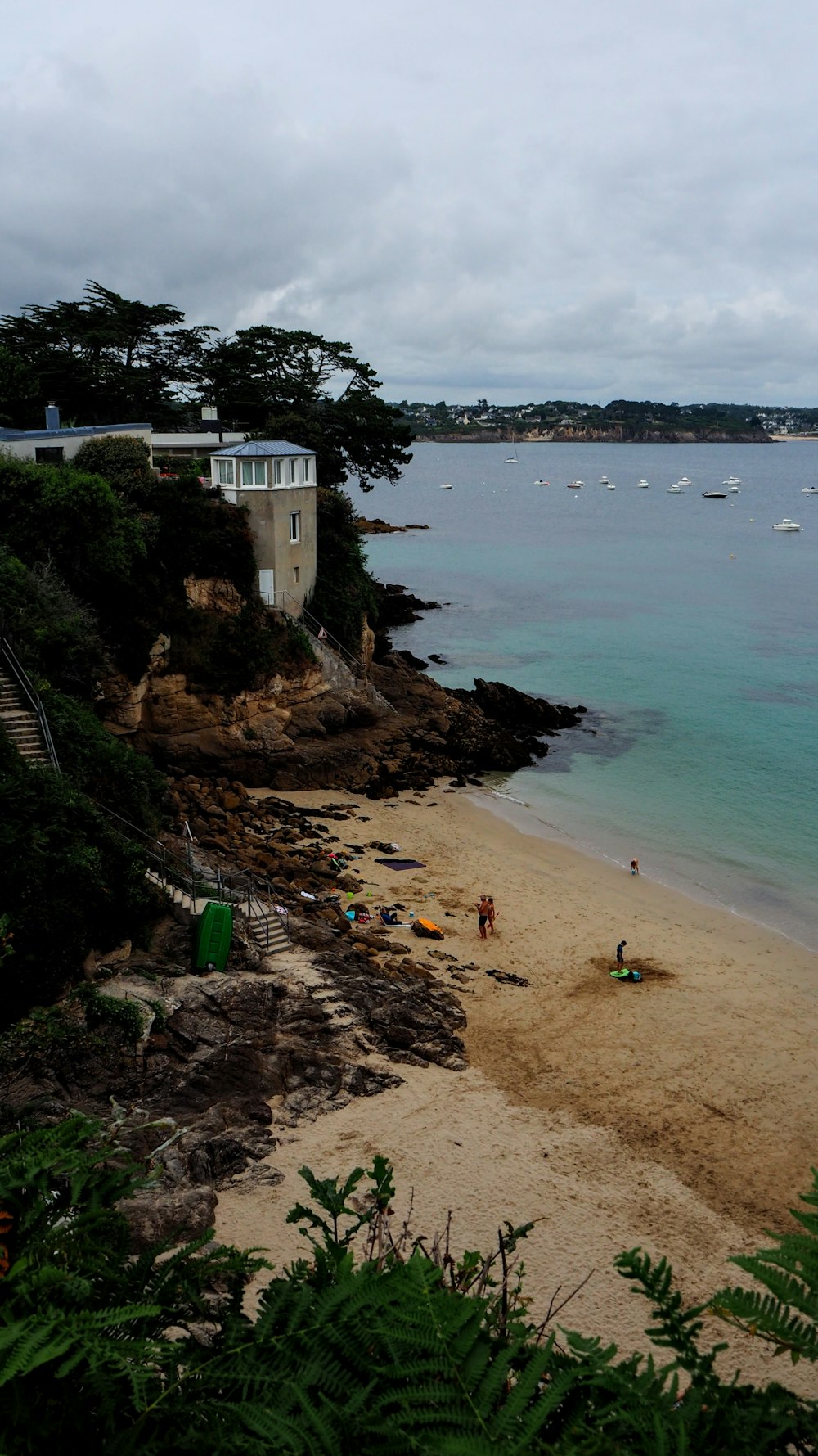 a sandy beach with people on it and boats in the water