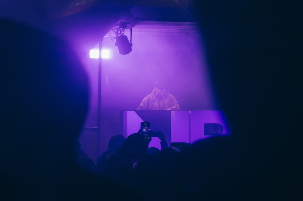 a person standing in front of a purple light