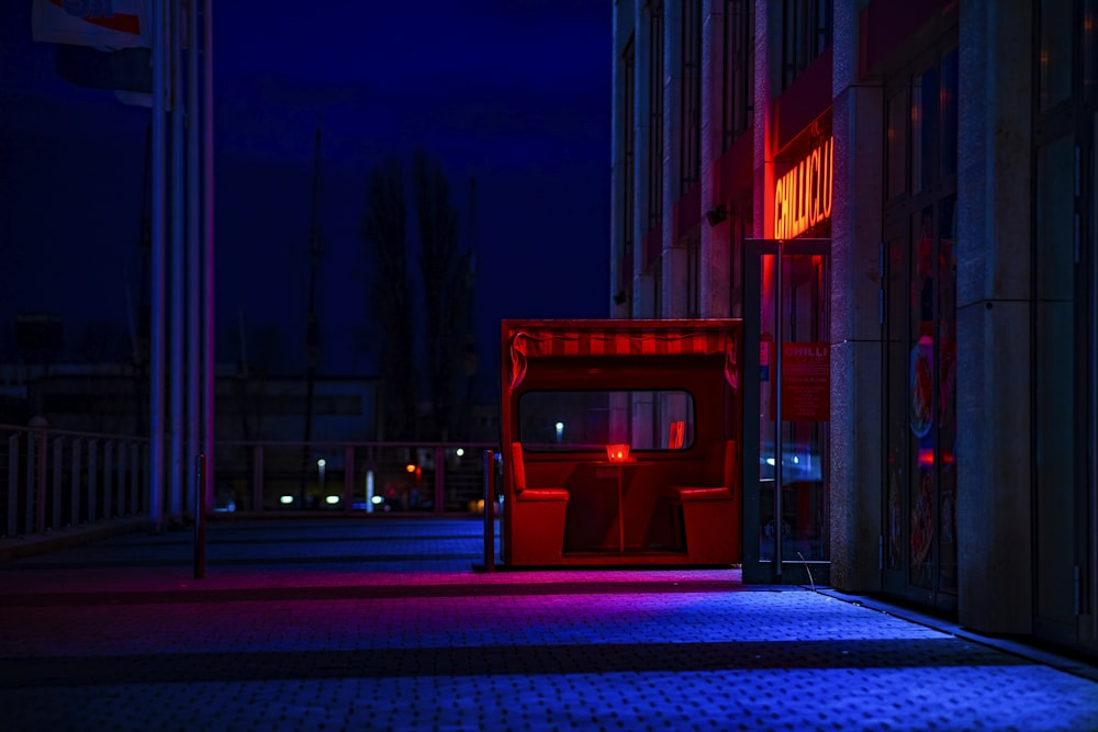 a red chair sitting on the side of a building