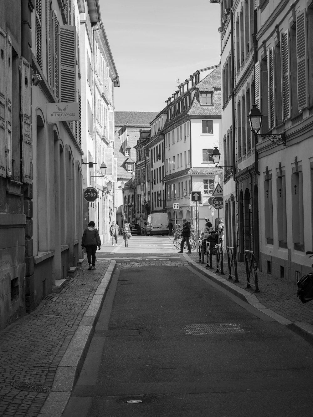 a black and white photo of a person walking down a street