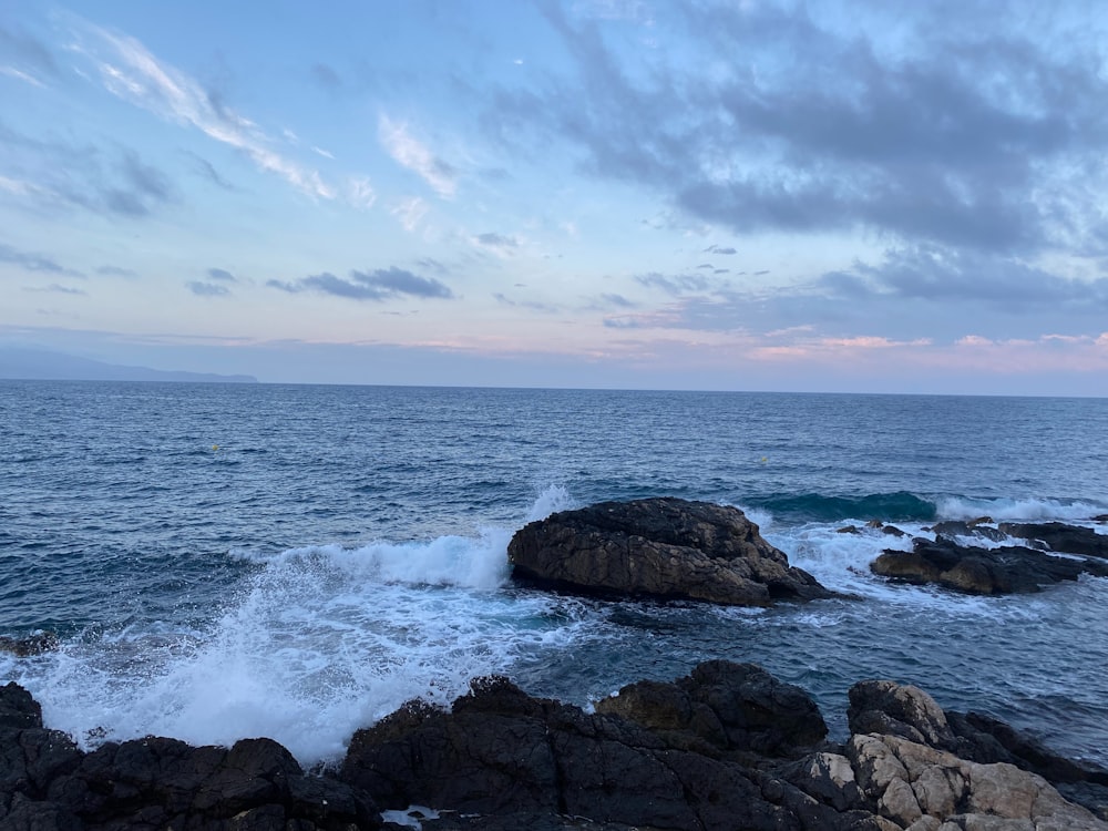 a large body of water next to a rocky shore