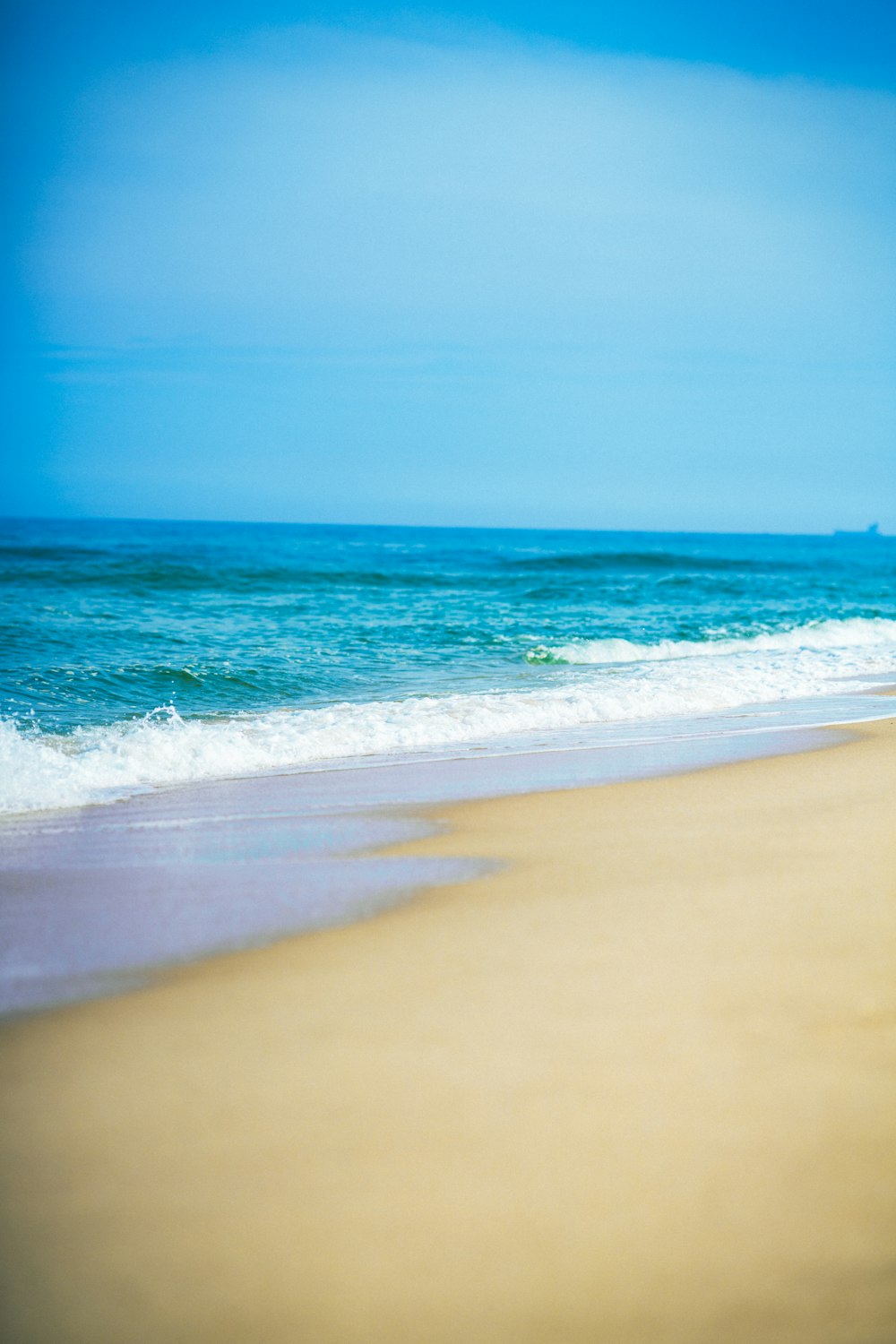 a person walking on the beach with a surfboard