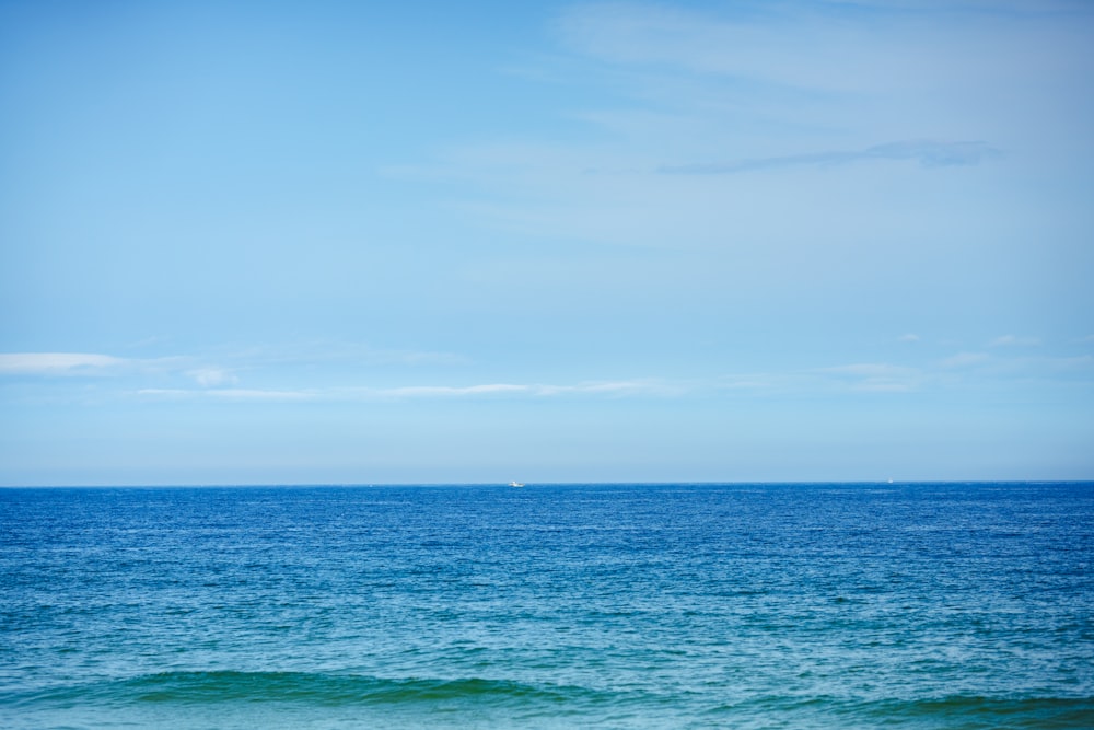 a large body of water sitting under a blue sky