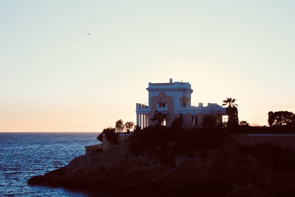 uma casa sentada no topo de um penhasco ao lado do oceano