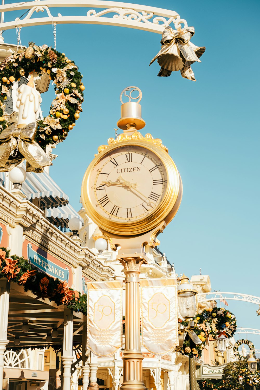 a large gold clock sitting in the middle of a street