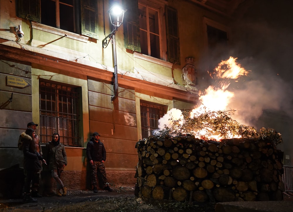 Un grupo de personas de pie alrededor de un pozo de fuego