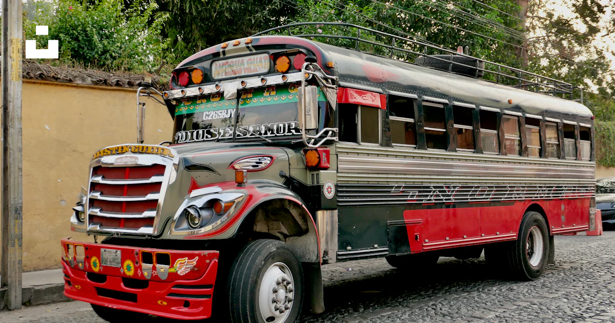 A red and black bus parked on the side of a road photo – Free Antigua ...