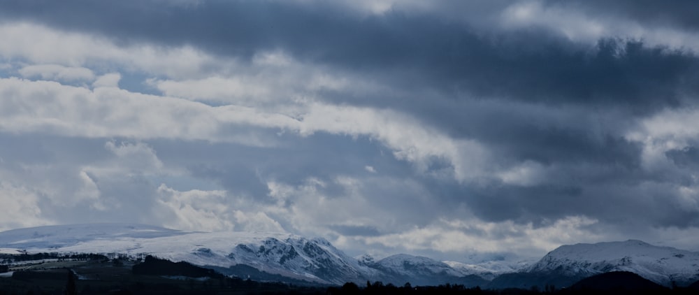 a cloudy sky with mountains in the background
