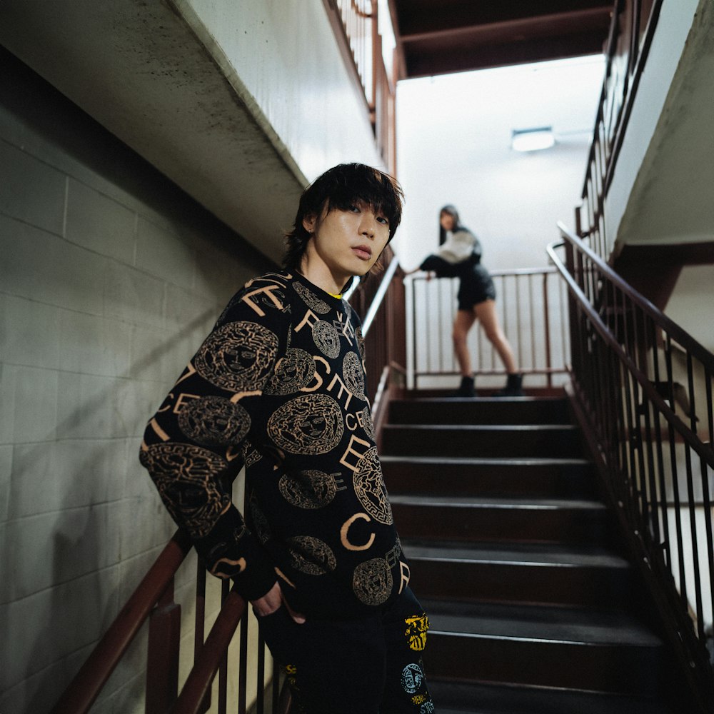 a man standing on a stair case next to a woman