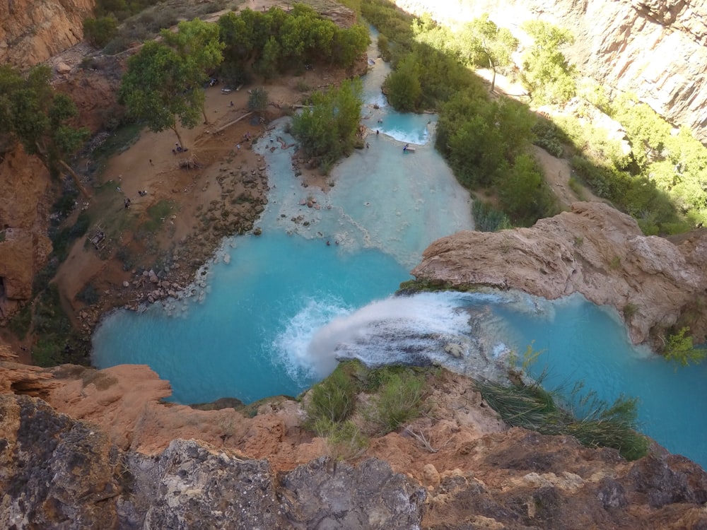 a river flowing into a canyon next to a lush green forest