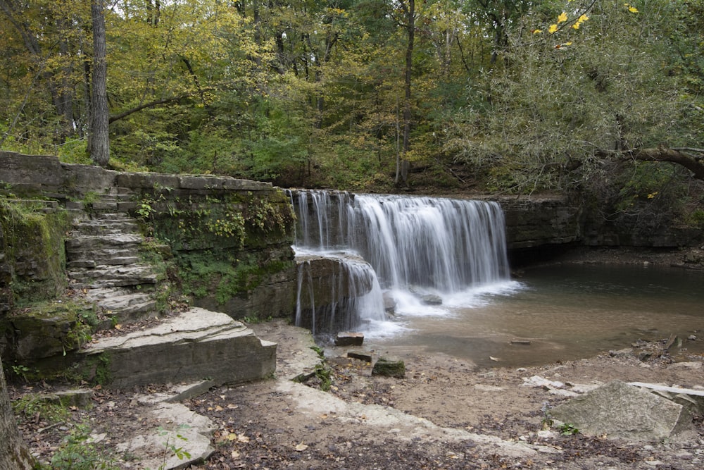 a waterfall in the middle of a wooded area