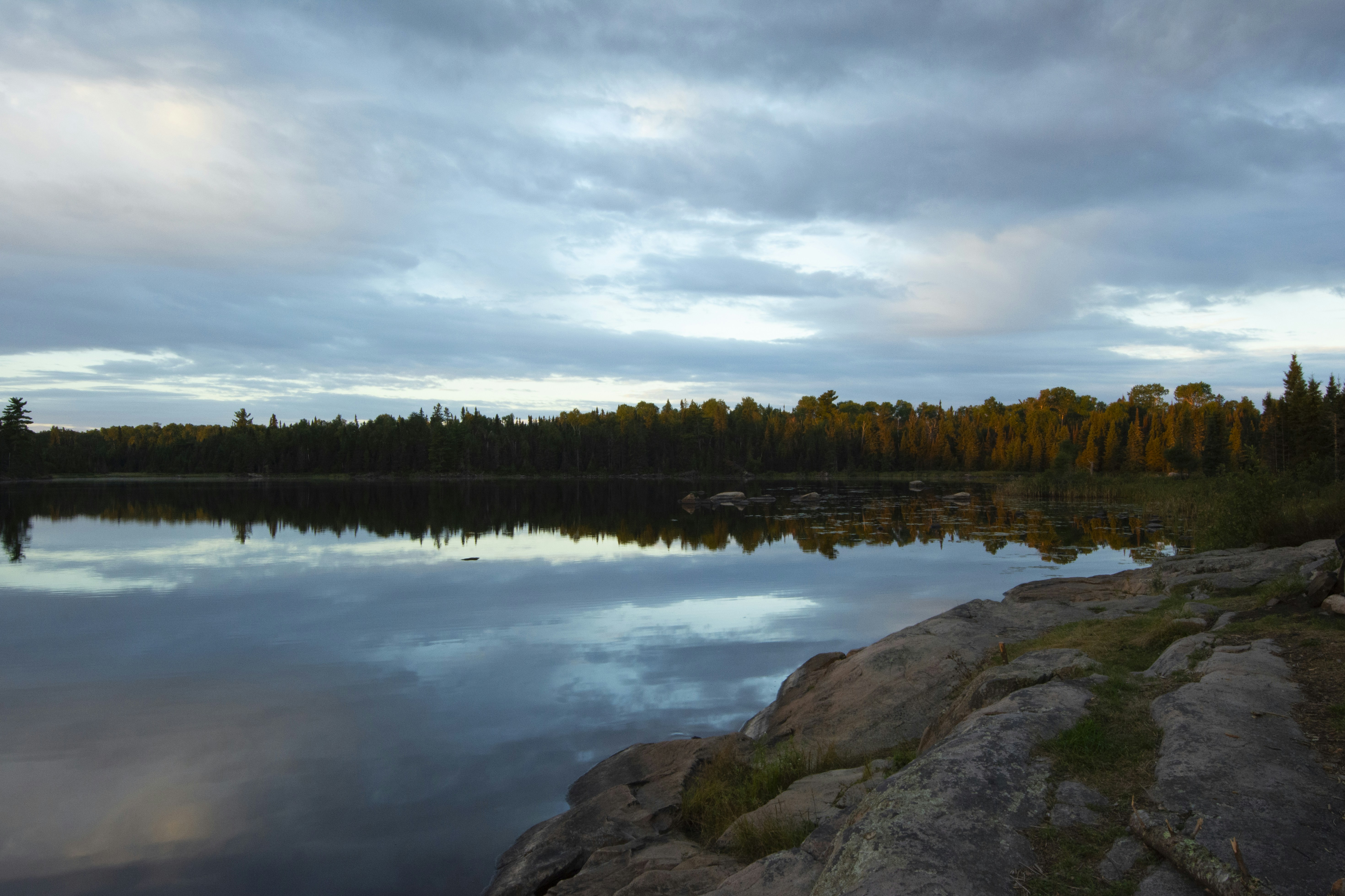 a body of water surrounded by rocks and trees