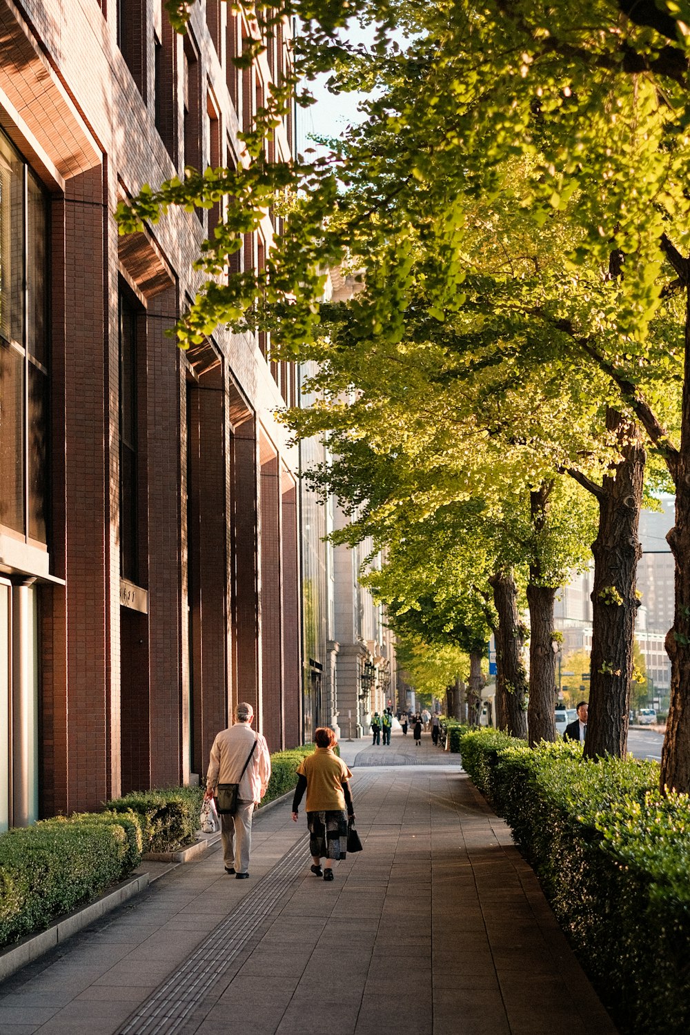 a couple of people walking down a sidewalk