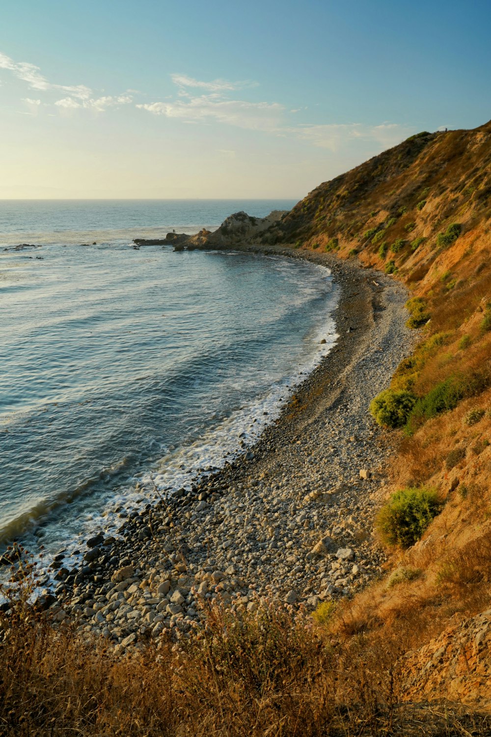 a view of a rocky beach with a body of water in the distance