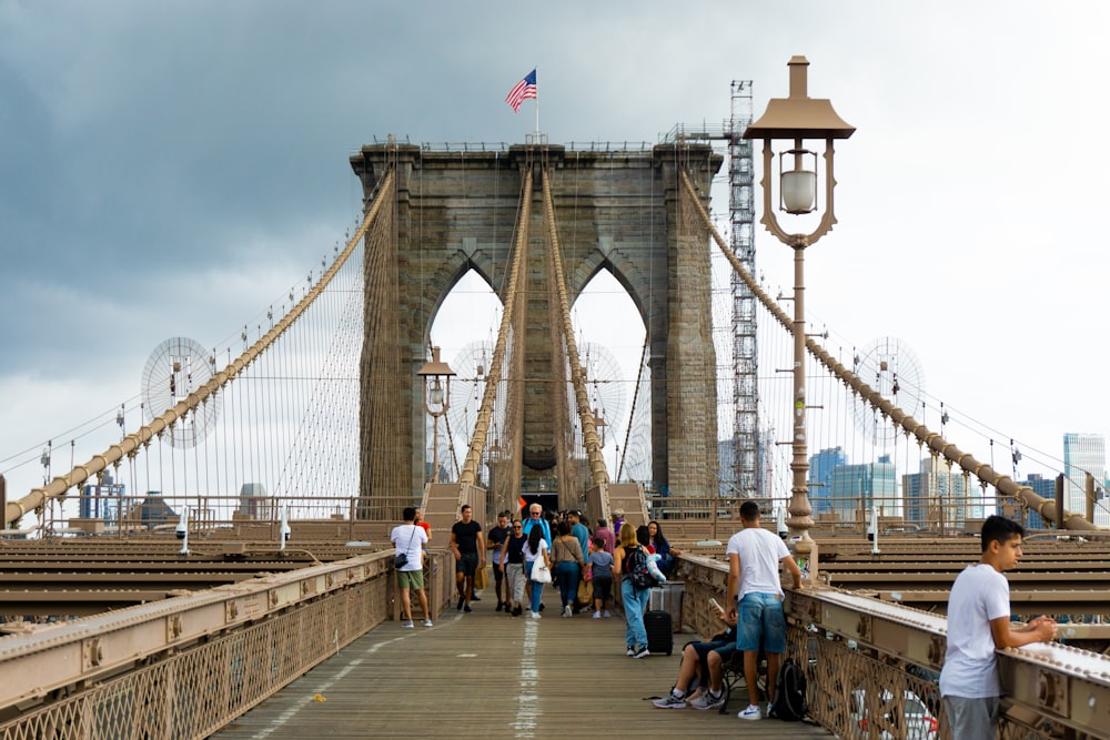 a group of people walking across a bridge