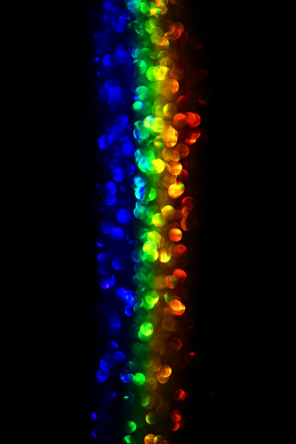 uma linha multicolorida de luzes no escuro