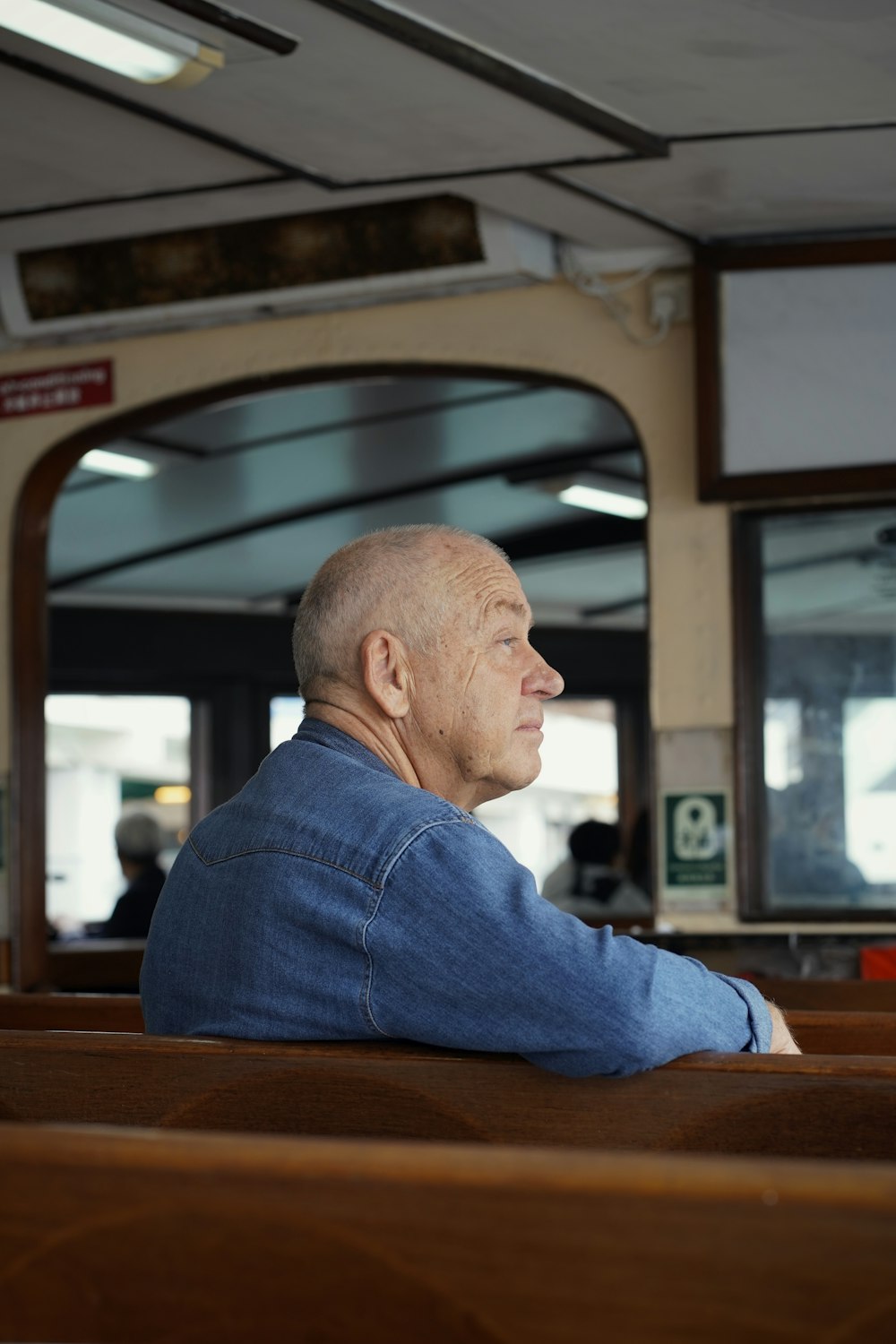 a man sitting in a church looking out the window