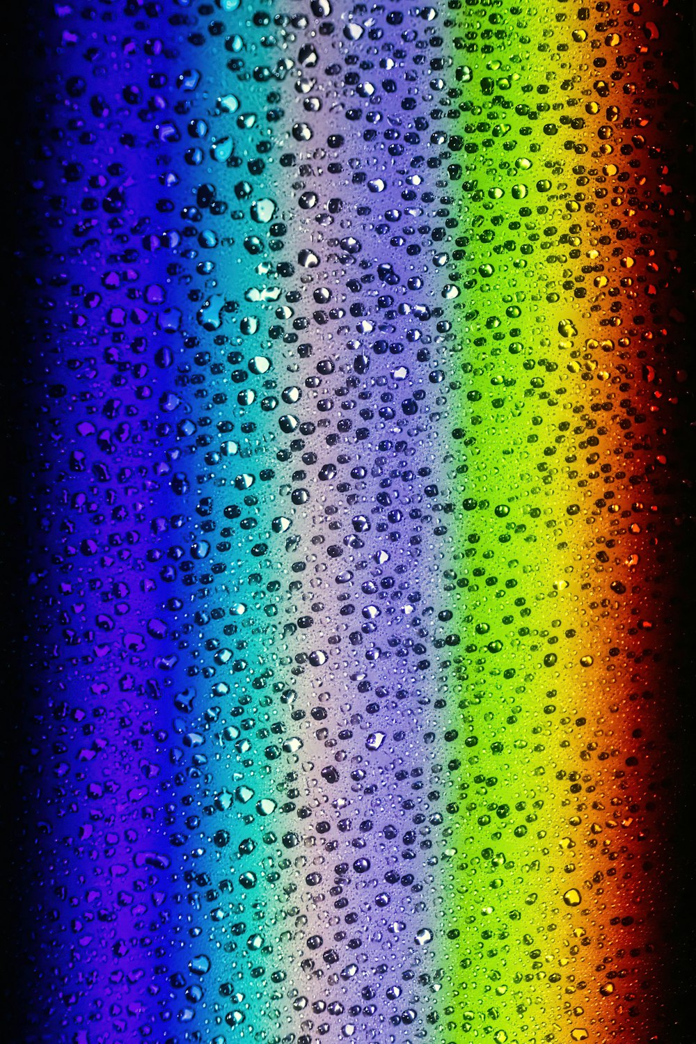 ein Regenbogen aus Wassertropfen auf schwarzem Hintergrund