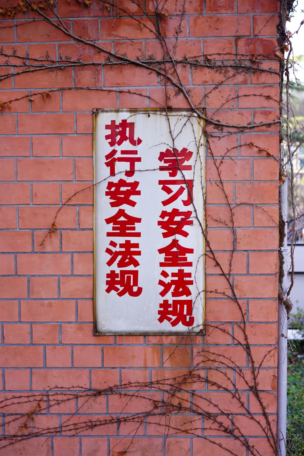 a red and white sign on a brick wall