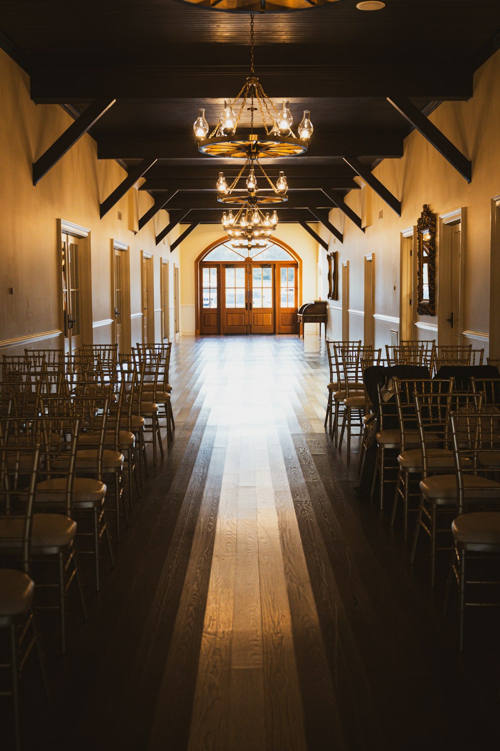 a large hall with rows of chairs and chandeliers
