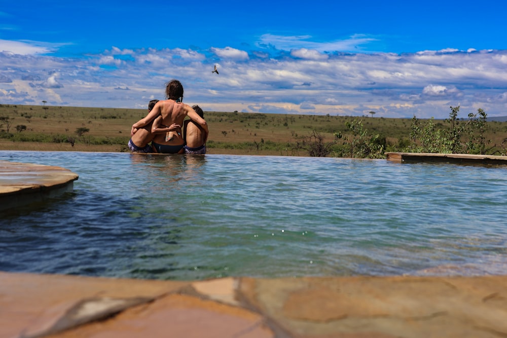 Un par de personas que están sentadas en una piscina