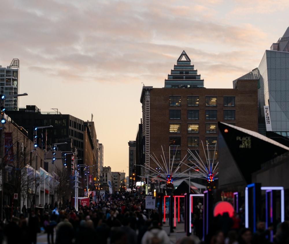 a crowd of people walking down a street next to tall buildings