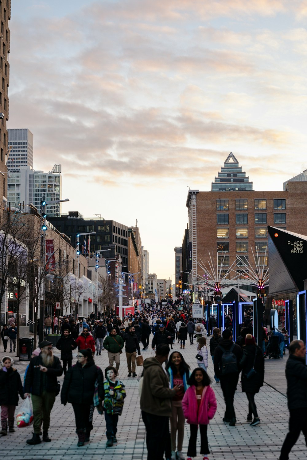 a crowd of people walking down a street next to tall buildings