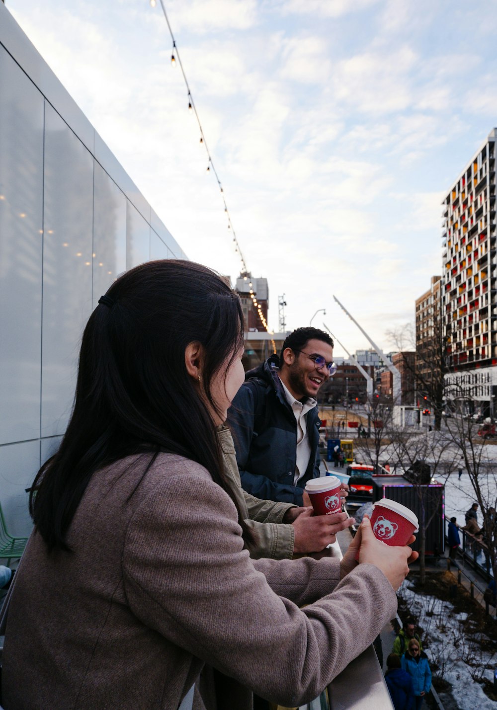 una donna che tiene una tazza di caffè accanto a un uomo