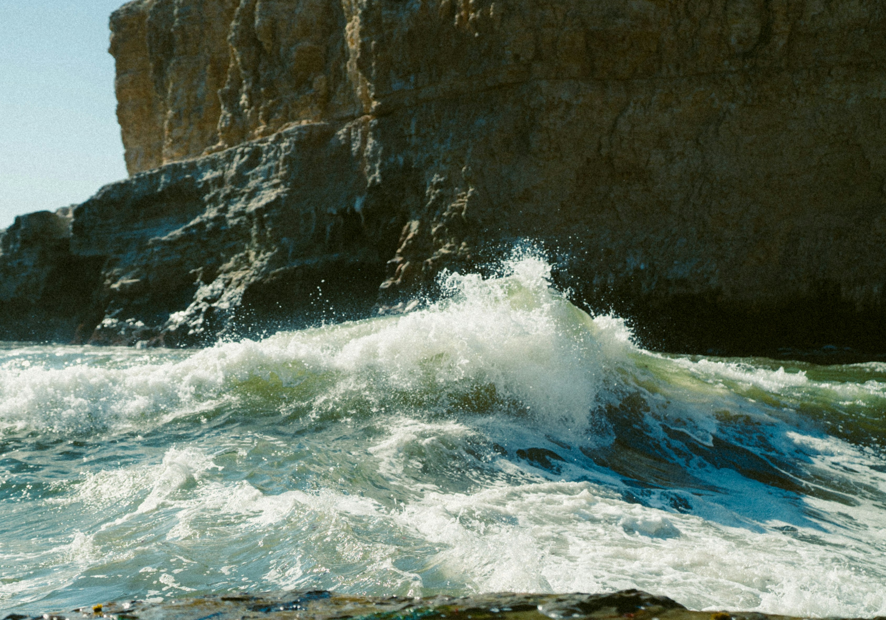 a large body of water next to a rocky cliff