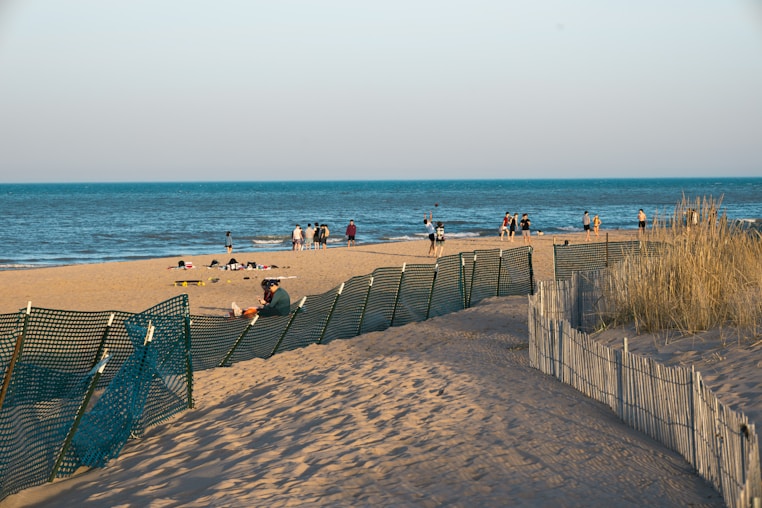 a group of people standing on top of a sandy beach