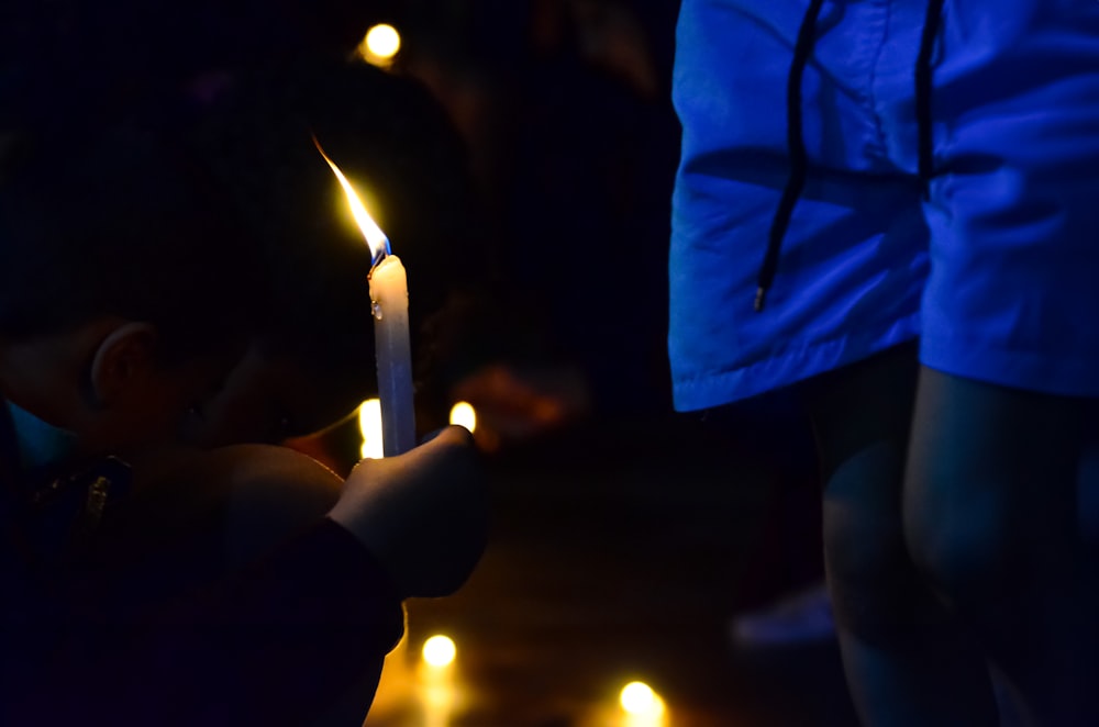 a young boy holding a lit candle in his hand