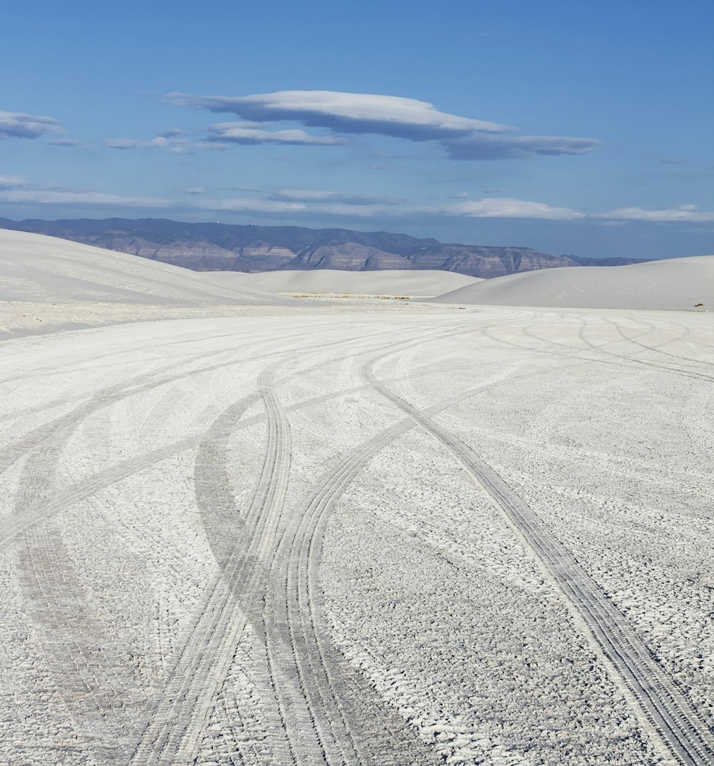 a person riding a snowboard down a snow covered road