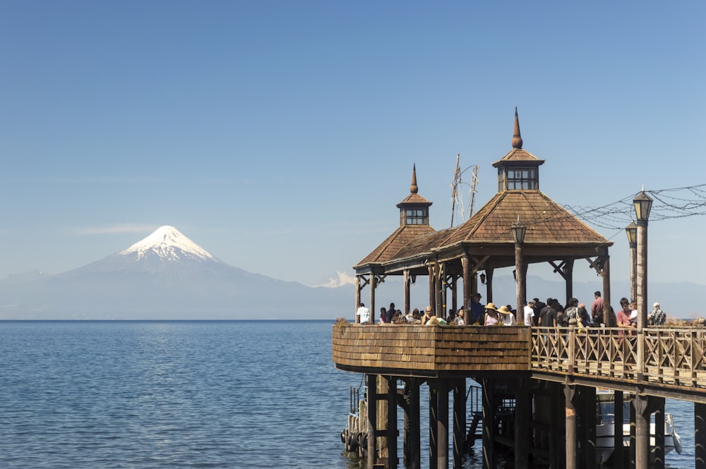 Ein Pier mit einem Pavillon und einem Berg im Hintergrund