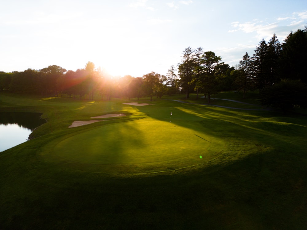 the sun is shining on a golf course