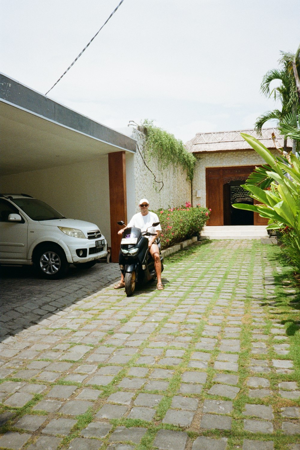 a man riding a scooter next to a white car