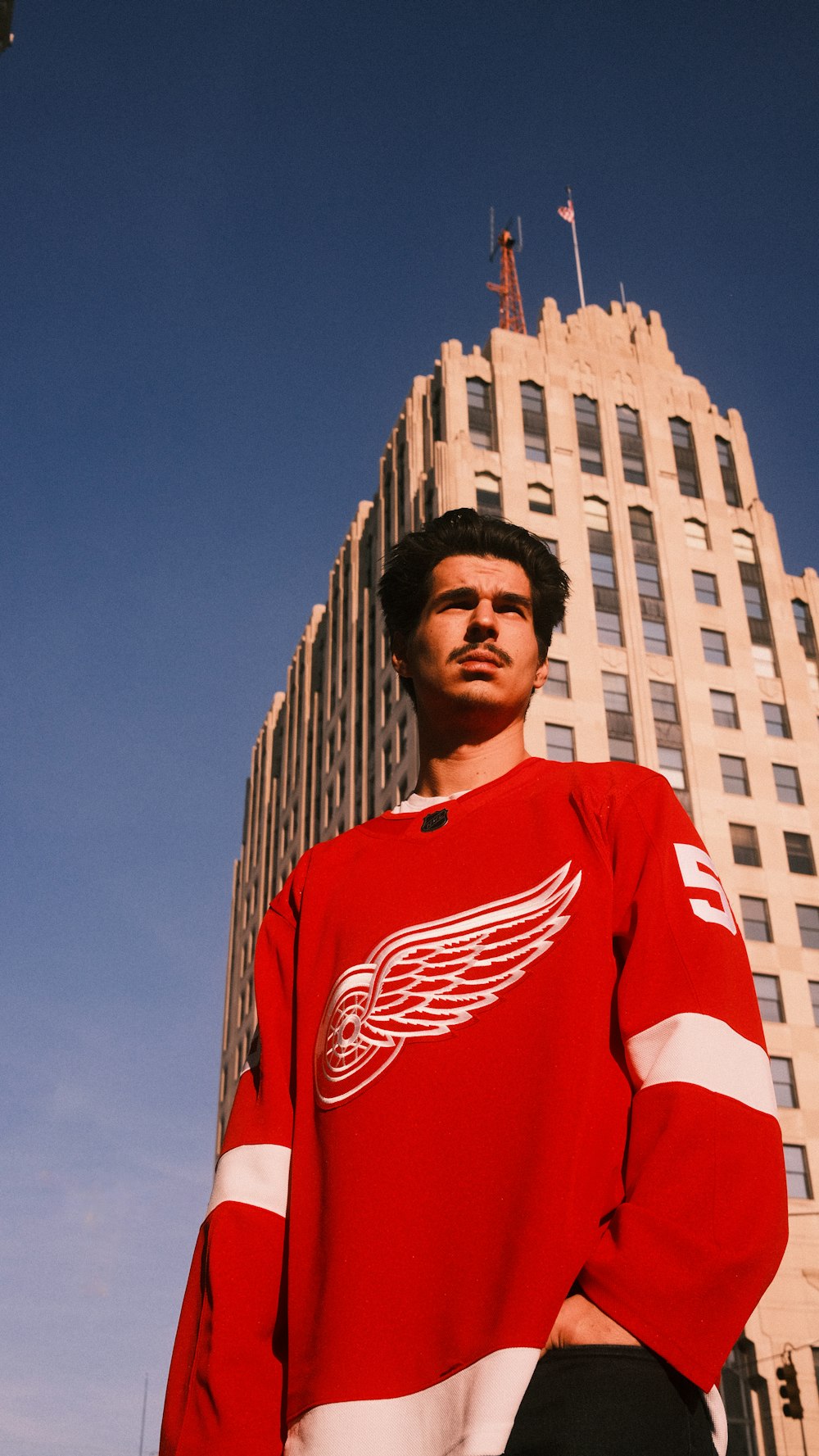 a man standing in front of a tall building