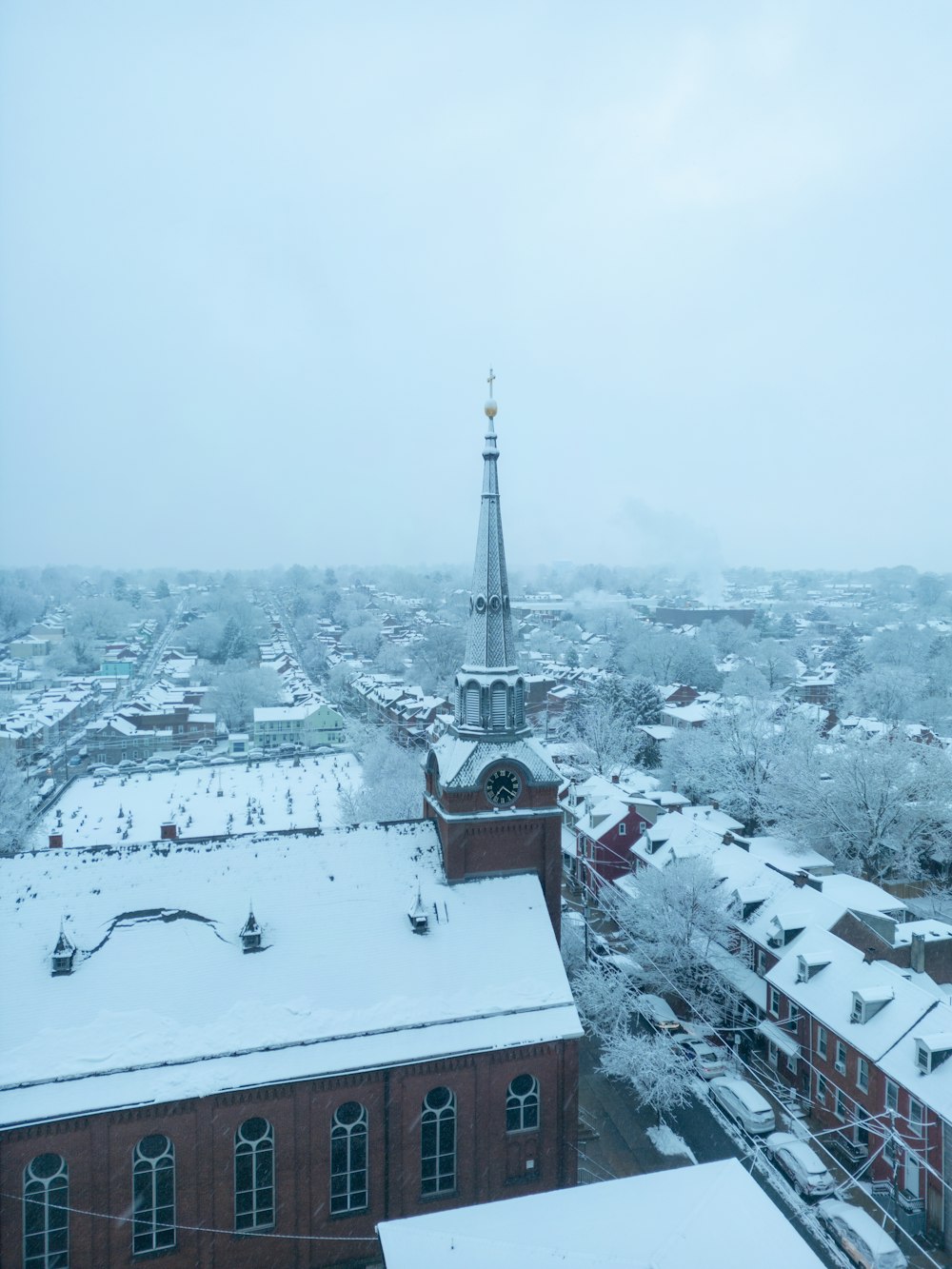 a snowy view of a city with a church steeple