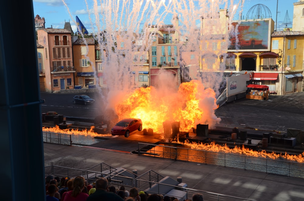 a car is on fire in front of a crowd of people